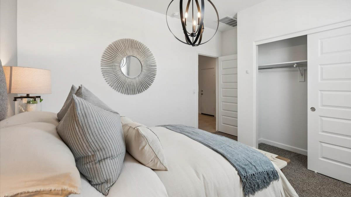 Comfortable guest bedroom featuring neutral-toned walls and a large closet.