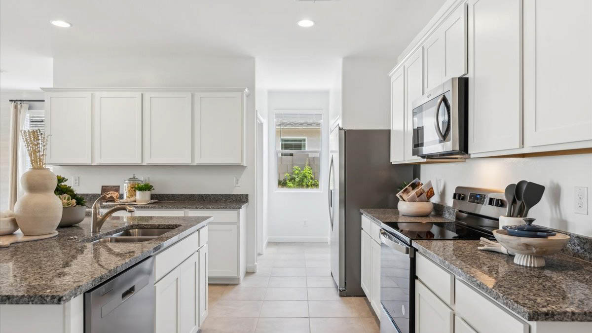 Bright and spacious kitchen with granite countertops, stainless steel appliances, and an island with bar seating.