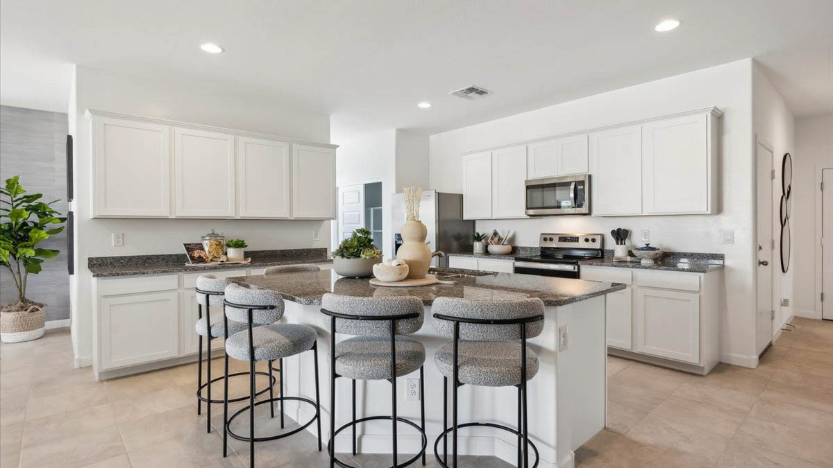 Bright and spacious kitchen with granite countertops, stainless steel appliances, and an island with bar seating.