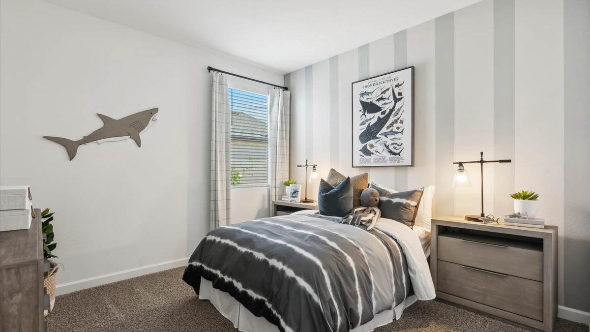 A vibrant kids' bedroom showcasing a neatly made bed, a stylish dresser, and a playful painting that adds charm.