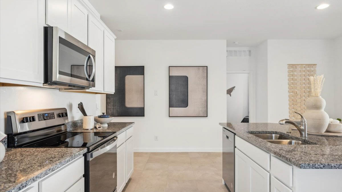 Bright and spacious kitchen with granite countertops, stainless steel appliances, and an island with bar seating.