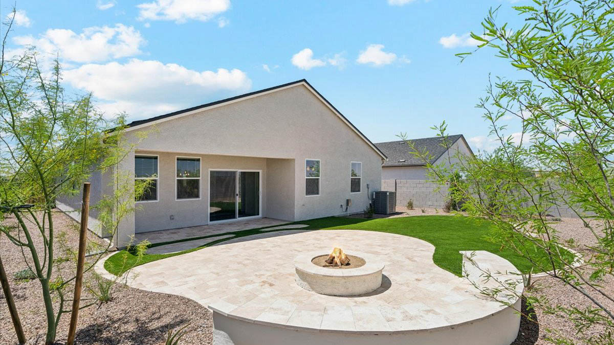 Outdoor covered patio with seating area overlooking a well-maintained lawn, perfect for relaxation.