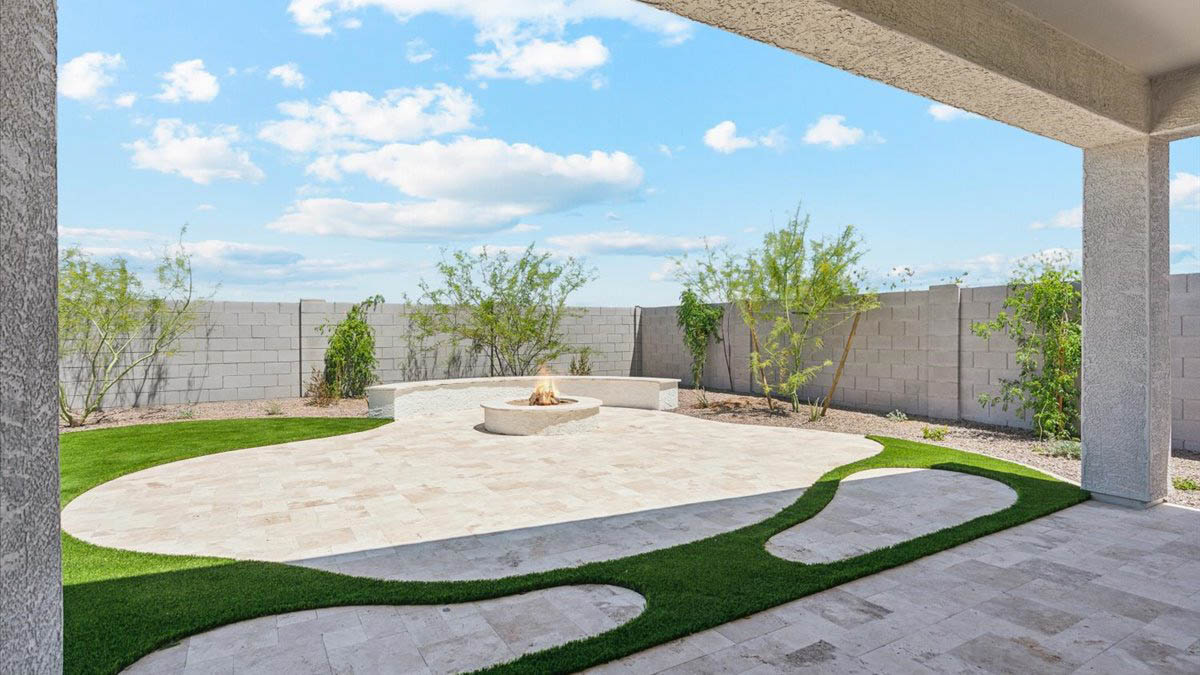 Outdoor covered patio with seating area overlooking a well-maintained lawn, perfect for relaxation.