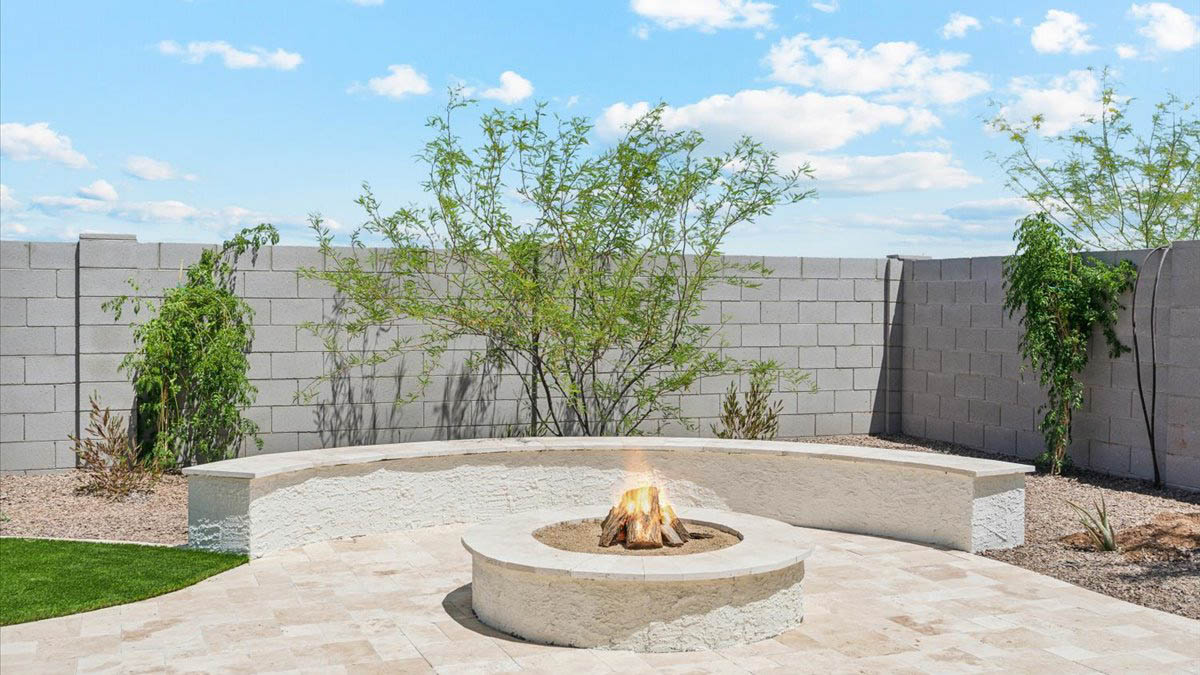 Outdoor covered patio with seating area overlooking a well-maintained lawn, perfect for relaxation.