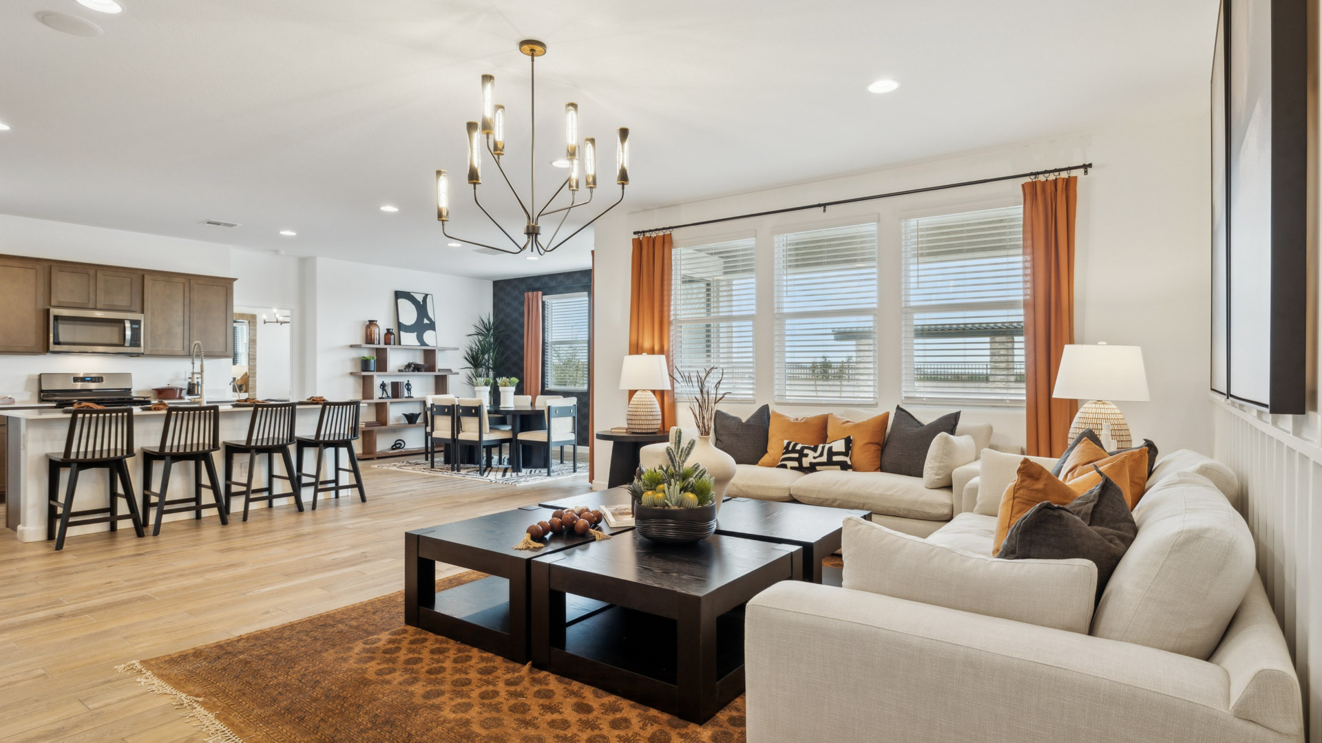 A well-organized living room that includes a kitchen and dining area, creating a warm and welcoming environment for gatherings.