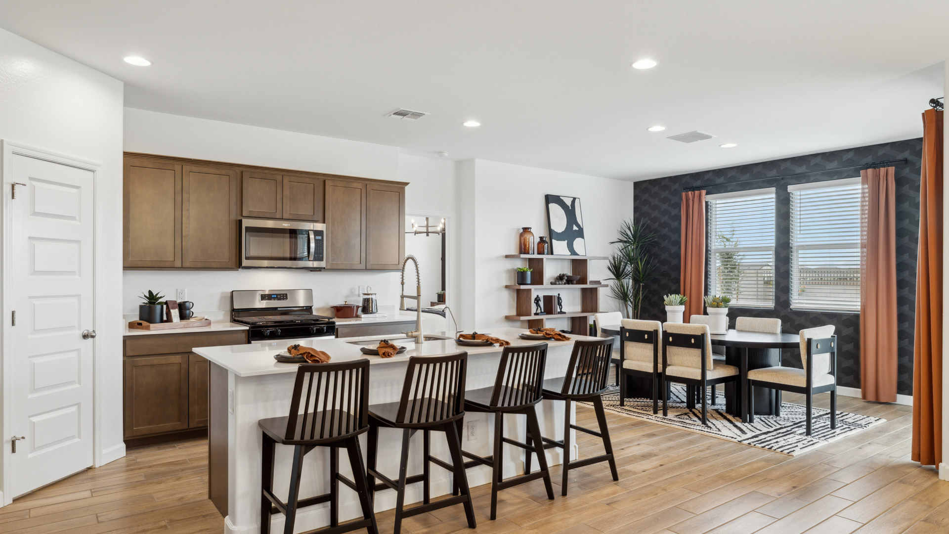 Bright and spacious kitchen with quartz countertops, stainless steel appliances, and an island with bar seating.