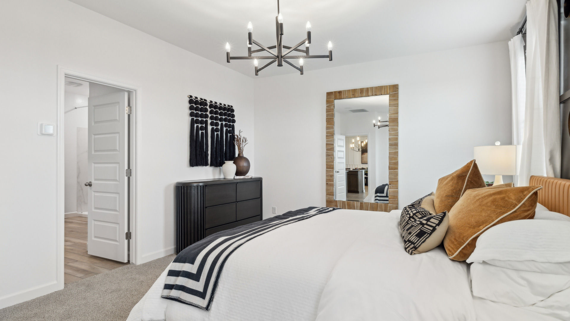 A spacious primary bedroom emphasizing open space and natural lighting.