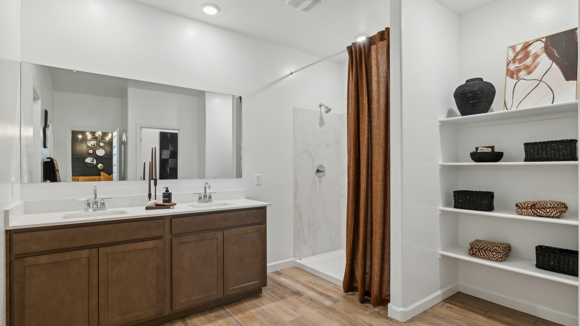 Modern primary bathroom with double vanities, quartz countertops with a walk-in shower and a walk-in closet.