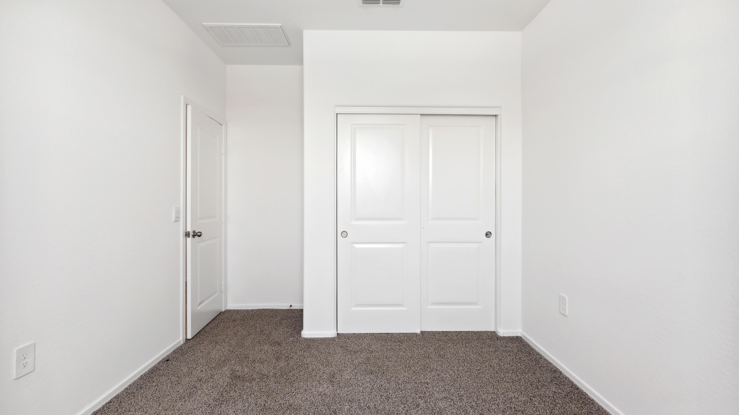 Comfortable guest bedroom featuring neutral-toned walls and a large closet.