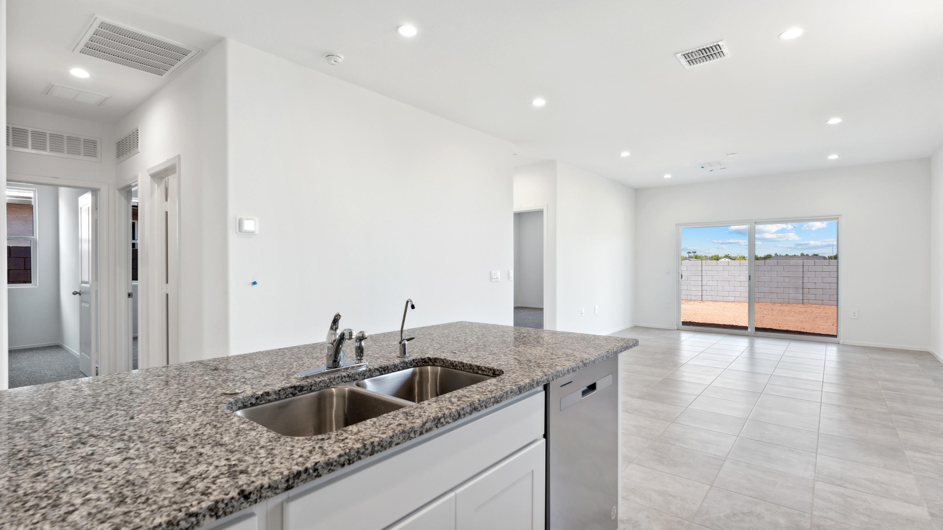Bright and spacious kitchen with granite countertops, stainless steel appliances, and an island with bar seating.