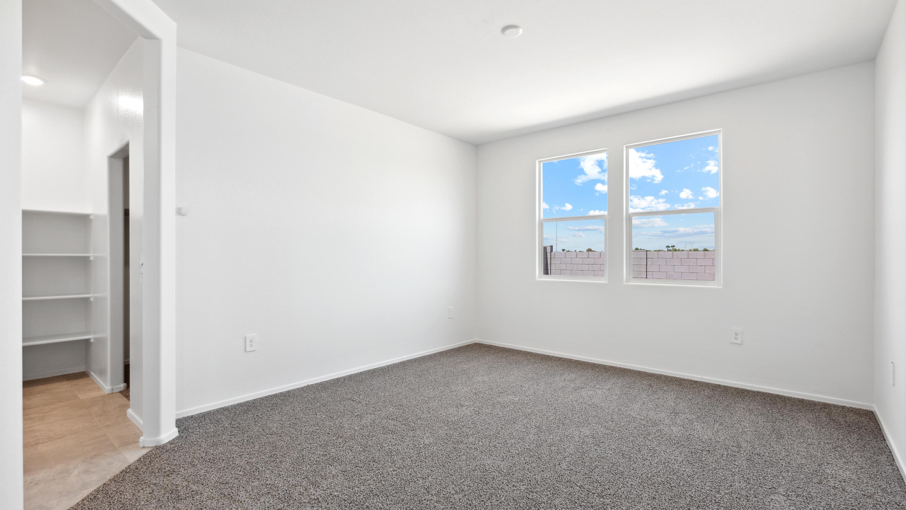 A spacious primary bedroom emphasizing open space and natural lighting.