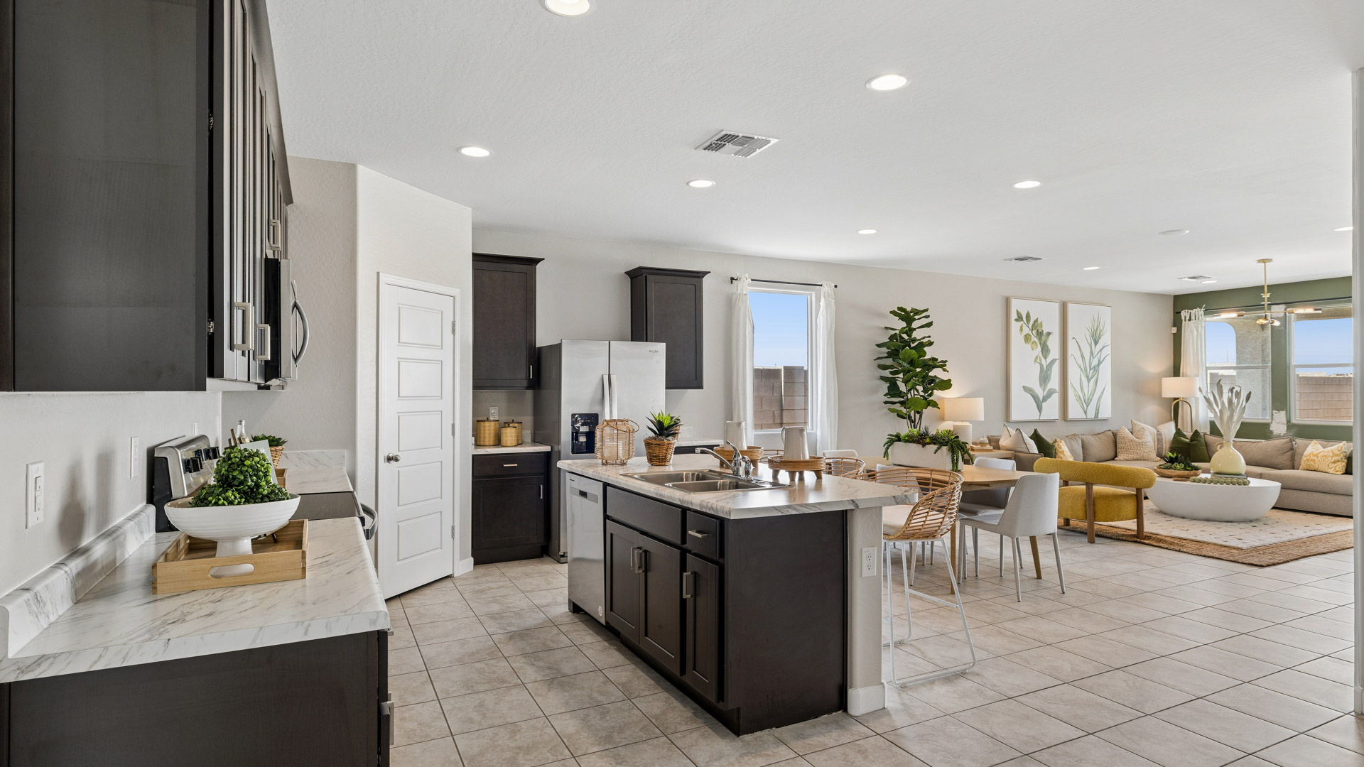 Bright and spacious kitchen with porcelain countertops, stainless steel appliances, and an island with bar seating.
