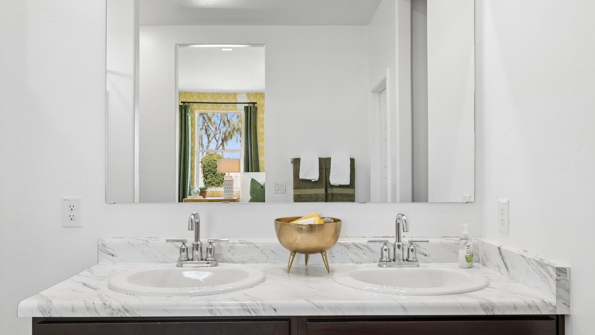 Modern primary bathroom with double vanities, porcelain countertops with a walk-in shower and a walk-in closet.