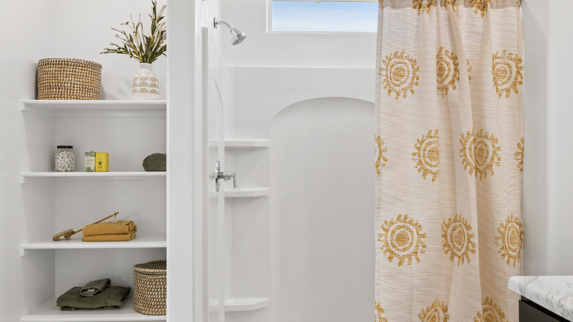 Modern primary bathroom with double vanities, porcelain countertops with a walk-in shower and a walk-in closet.