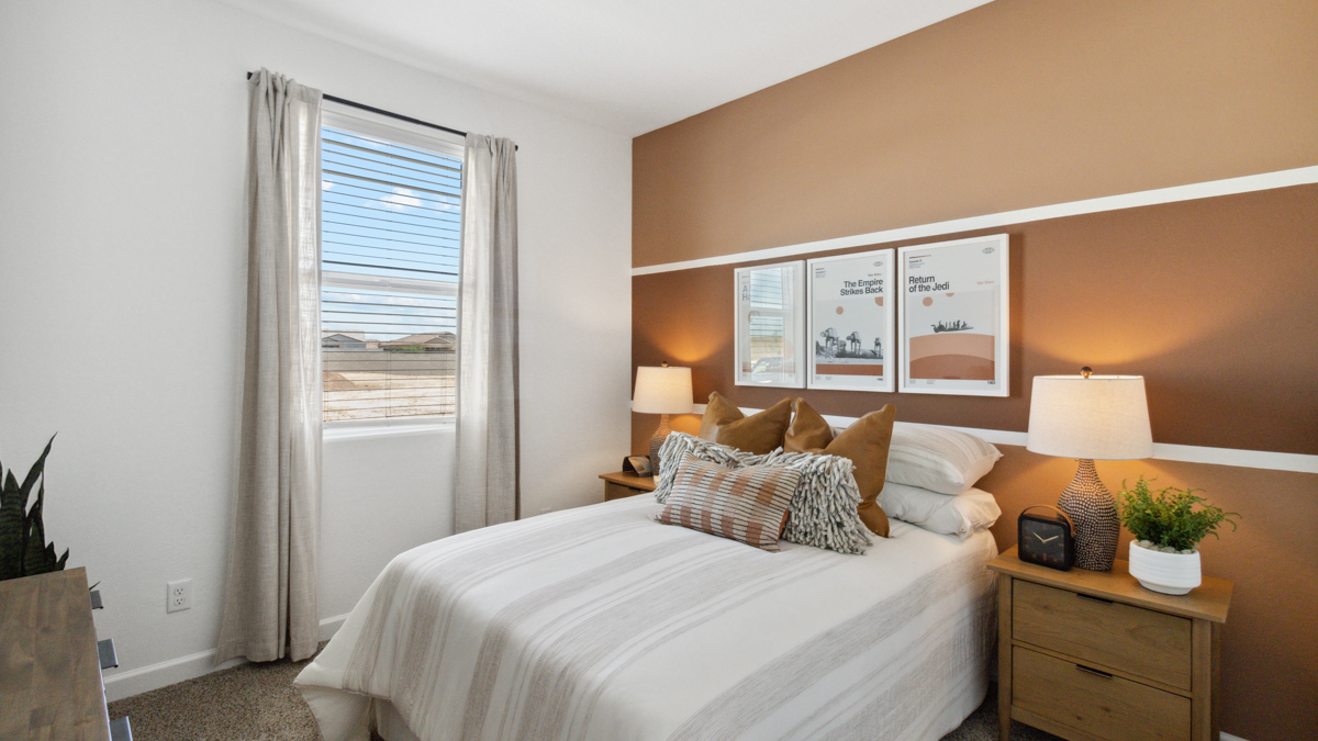 A vibrant kids' bedroom showcasing a neatly made bed, a stylish dresser, and a playful painting that adds charm.