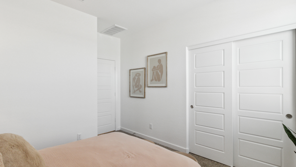 A vibrant kids' bedroom showcasing a neatly made bed, a stylish dresser, and a playful painting that adds charm.