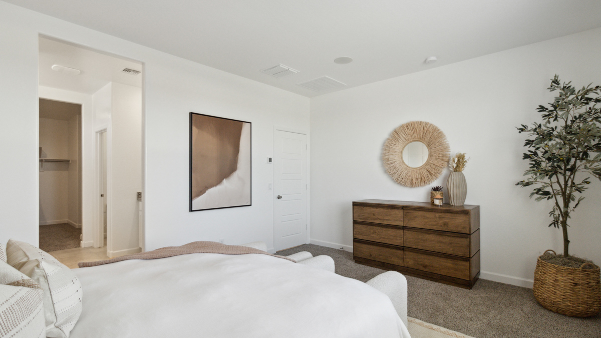A spacious primary bedroom emphasizing open space and natural lighting.