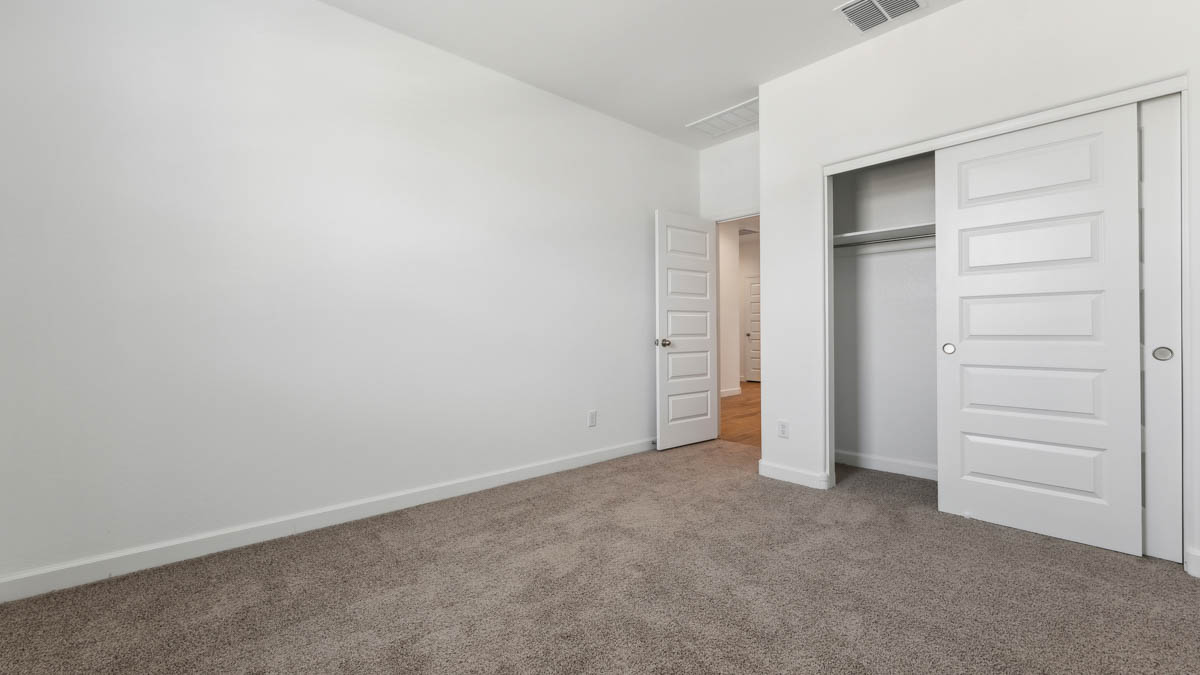 Guest bedroom with carpet, closet, and window.