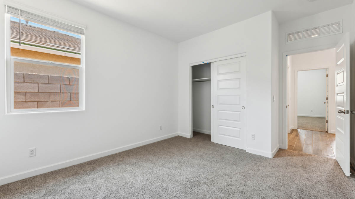 Guest bedroom with carpet, closet, and window.