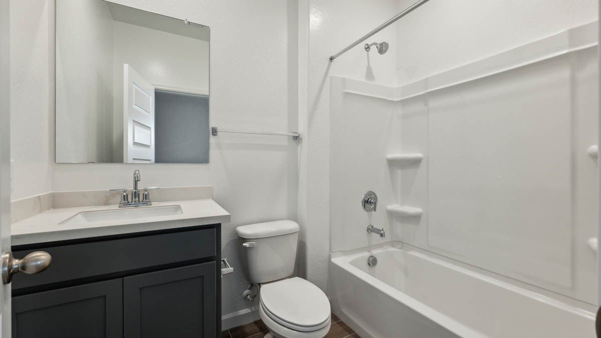Guest bathroom with one sink, shower, and a toilet.