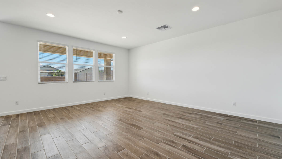 Living room area with large windows and hardwood floors.