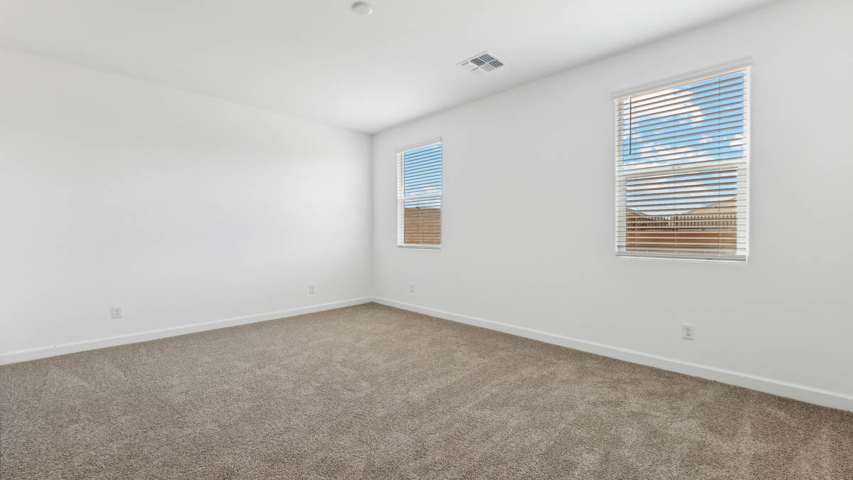 Large primary bedroom with carpet, large window, and primary bathroom connected.