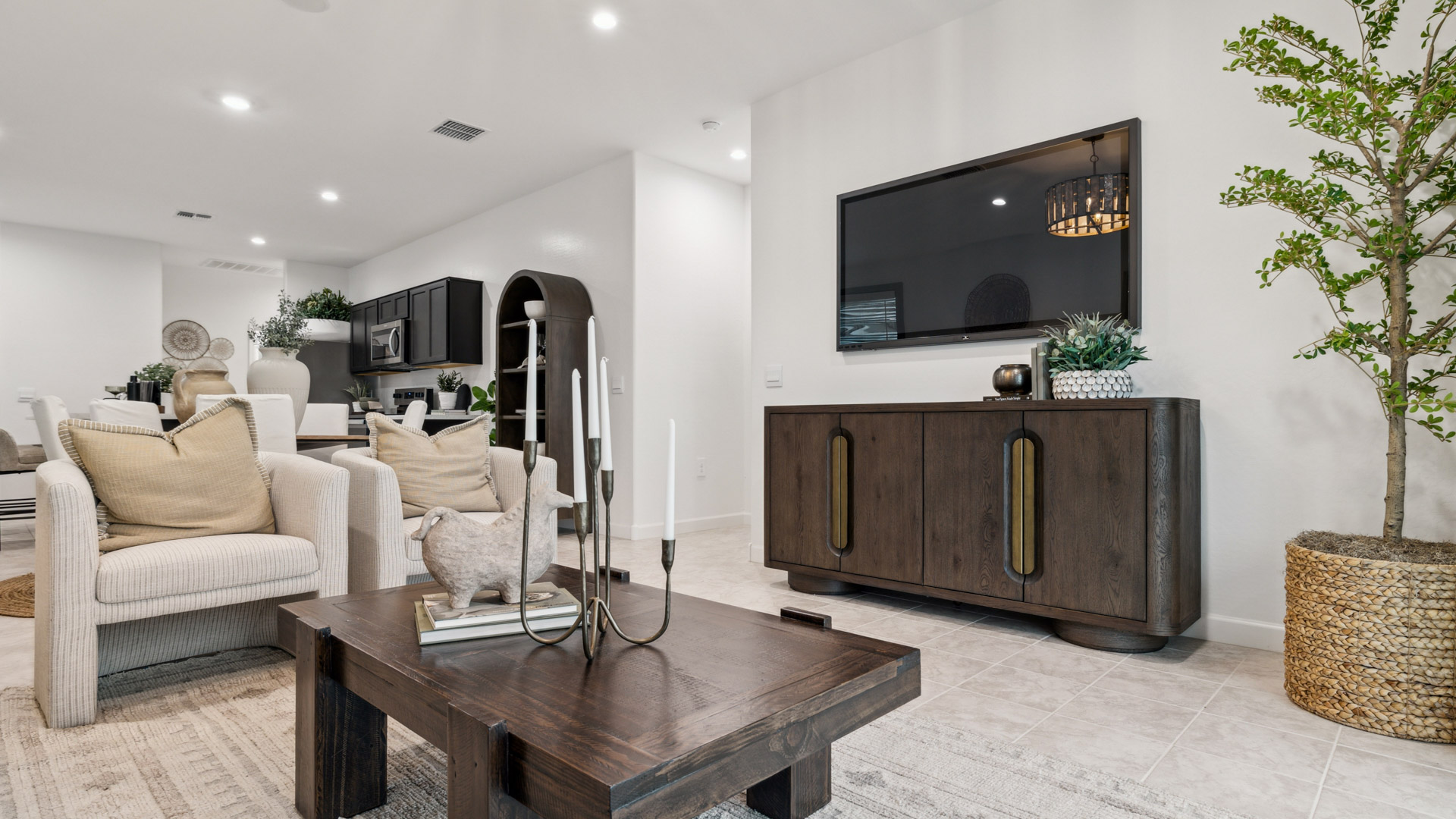A cozy living room feature vinyl wood flooring and a view to the kitchen and dining area.