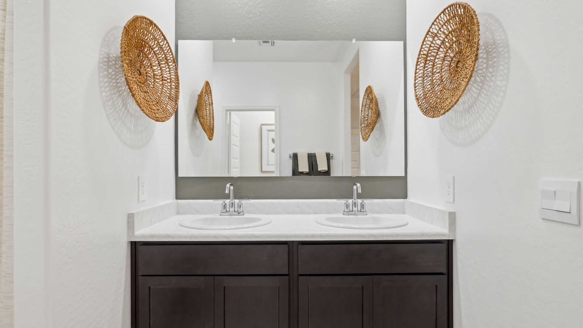 Modern primary bathroom with double vanities, with a walk-in shower and a walk-in closet.