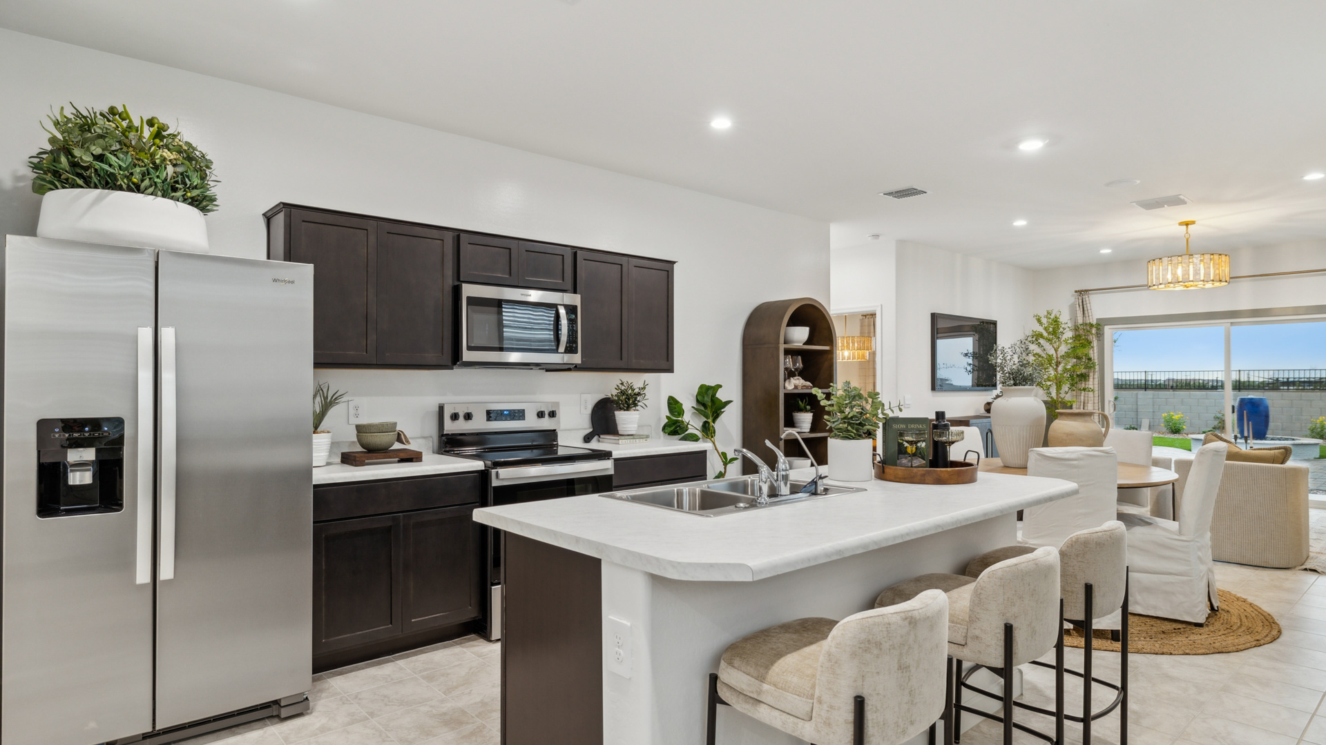 Bright and spacious kitchen with countertops, stainless steel appliances, and an island with bar seating.