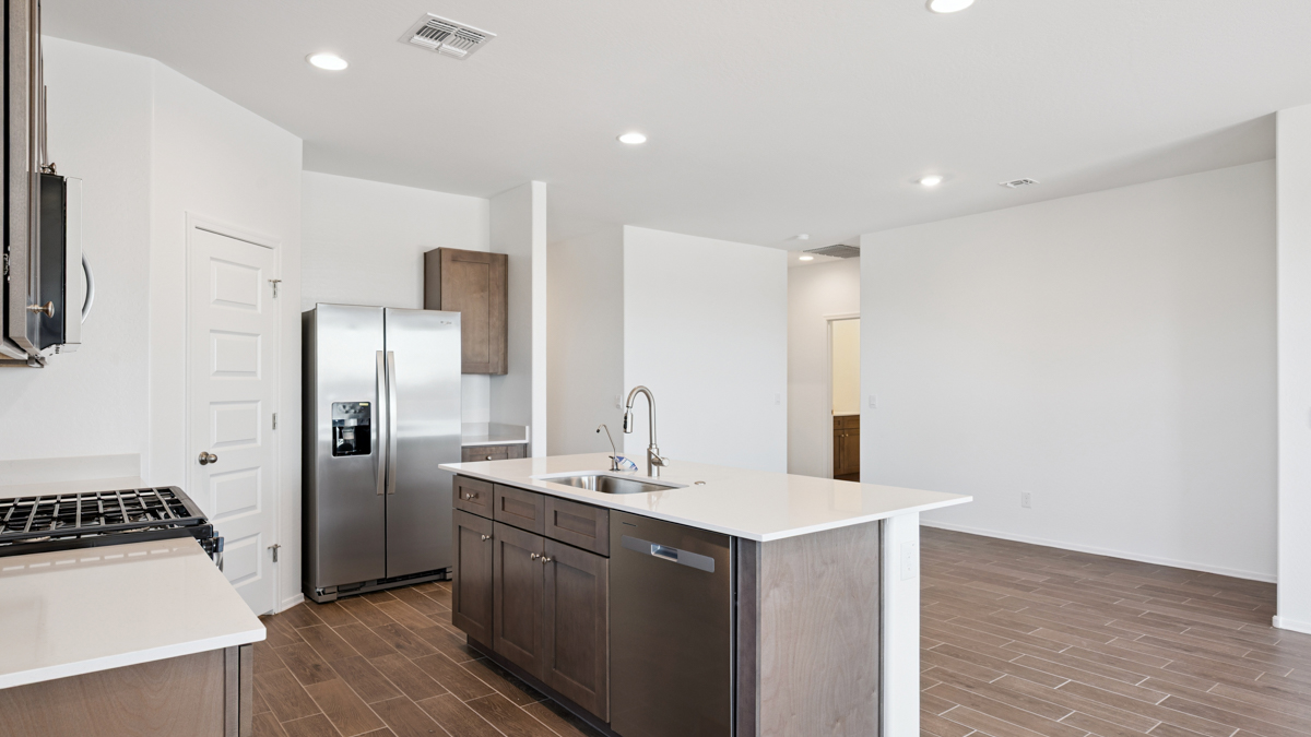 Bright and spacious kitchen with quartz countertops, stainless steel appliances, and an island with bar seating.