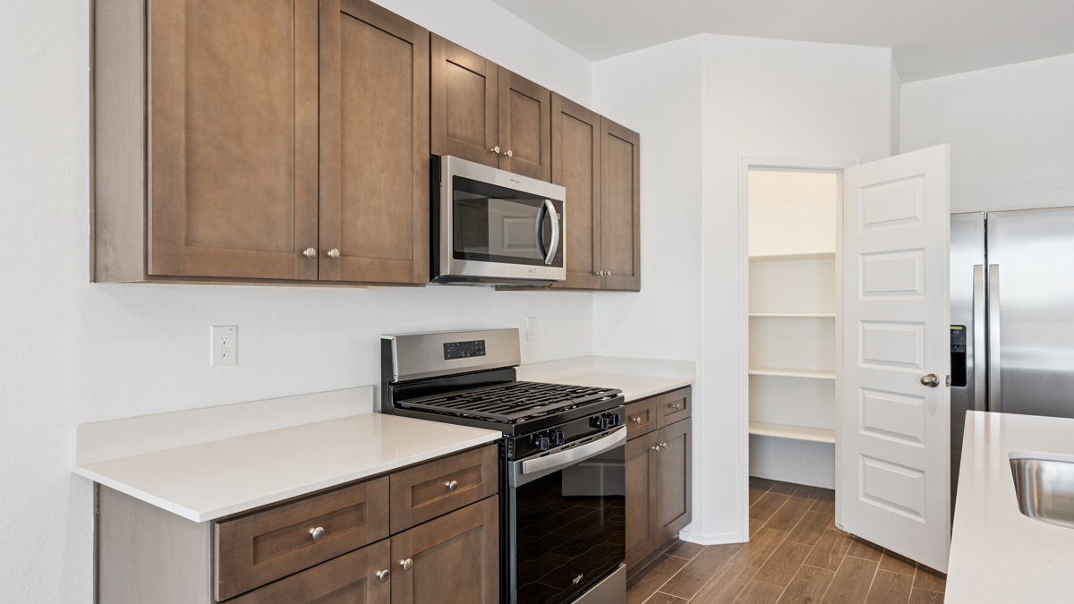 Bright and spacious kitchen with quartz countertops, stainless steel appliances, and an island with bar seating.
