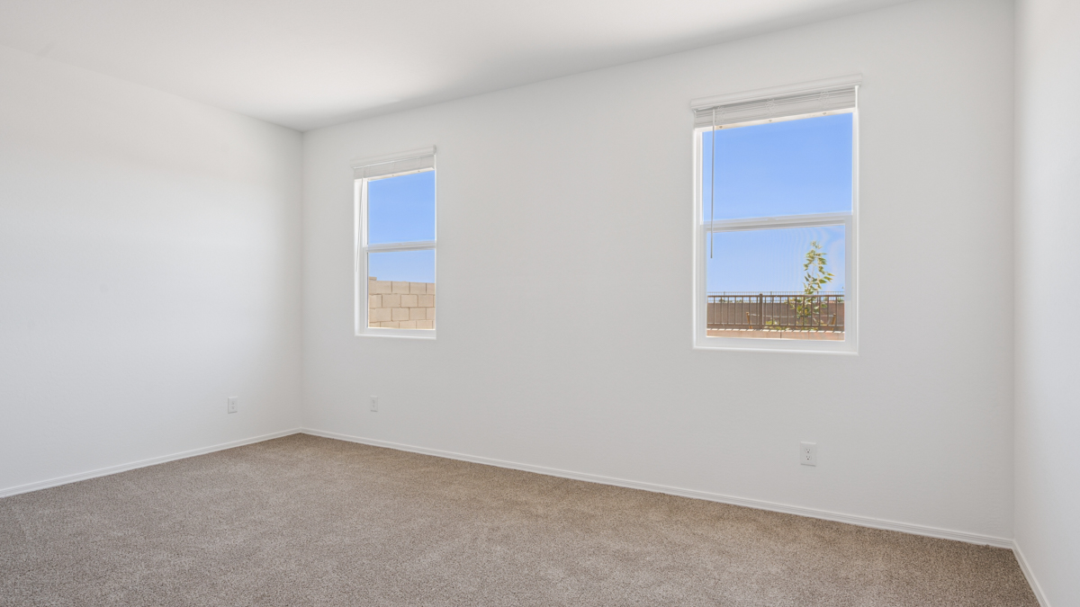 A spacious primary bedroom emphasizing open space and natural lighting.