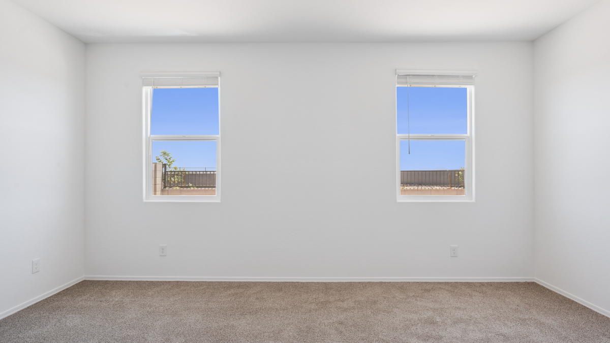 A spacious primary bedroom emphasizing open space and natural lighting.