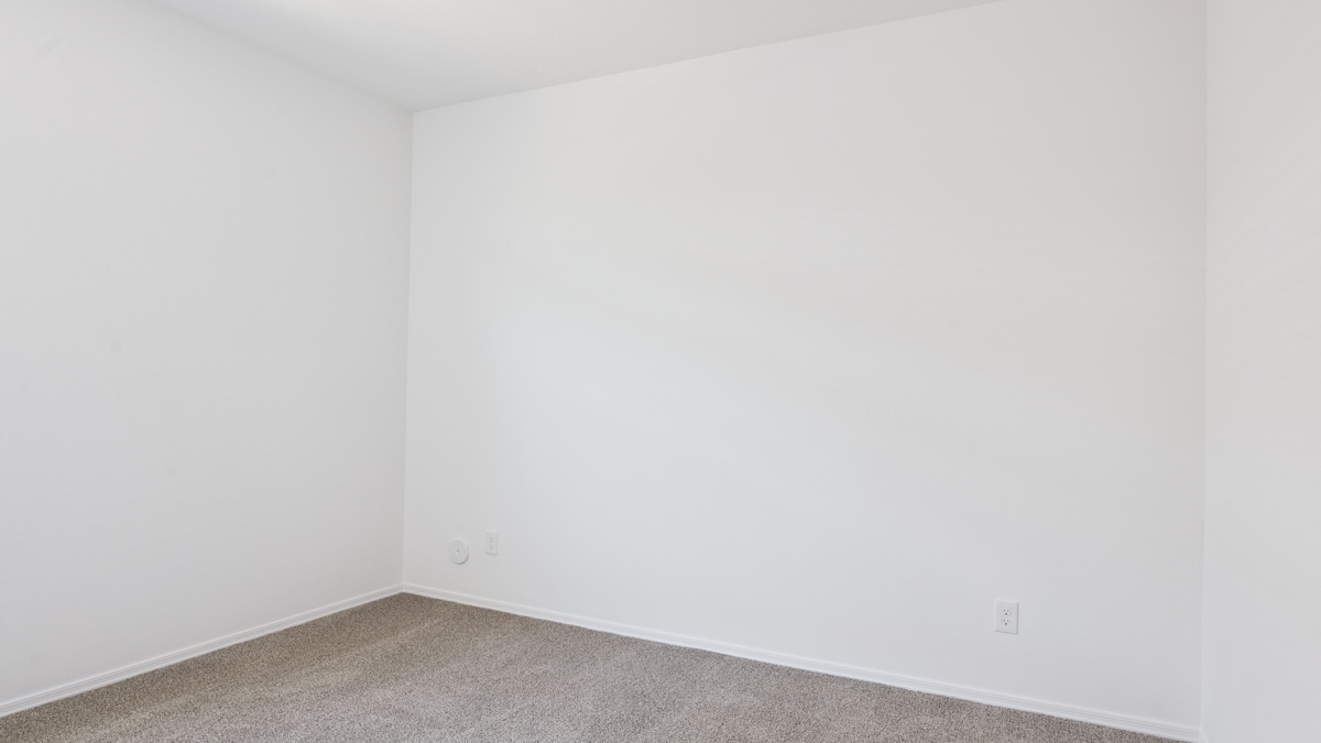 Comfortable guest bedroom featuring neutral-toned walls and a large closet.