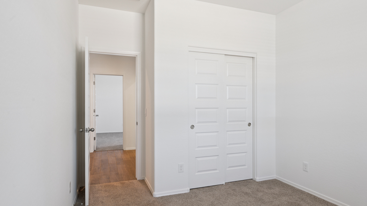 Comfortable guest bedroom featuring neutral-toned walls and a large closet.