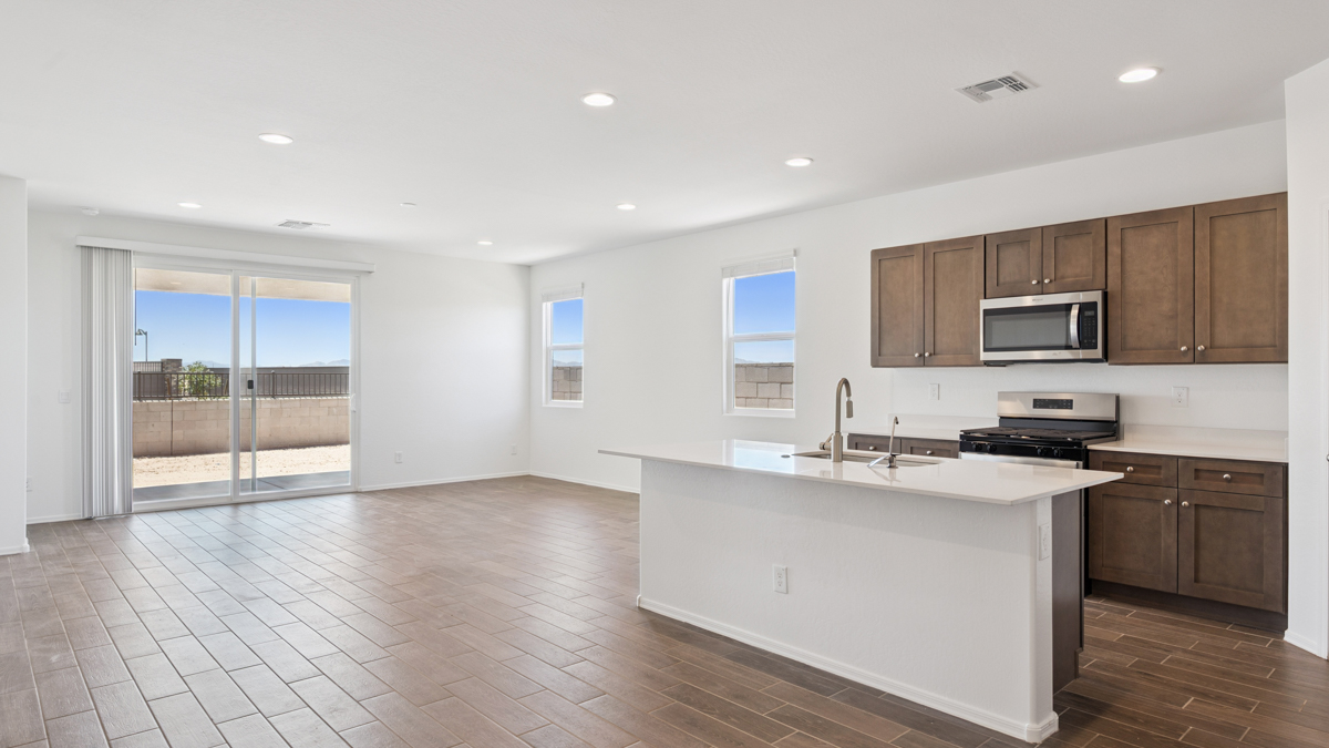 Bright and spacious kitchen with quartz countertops, stainless steel appliances, and an island with bar seating.