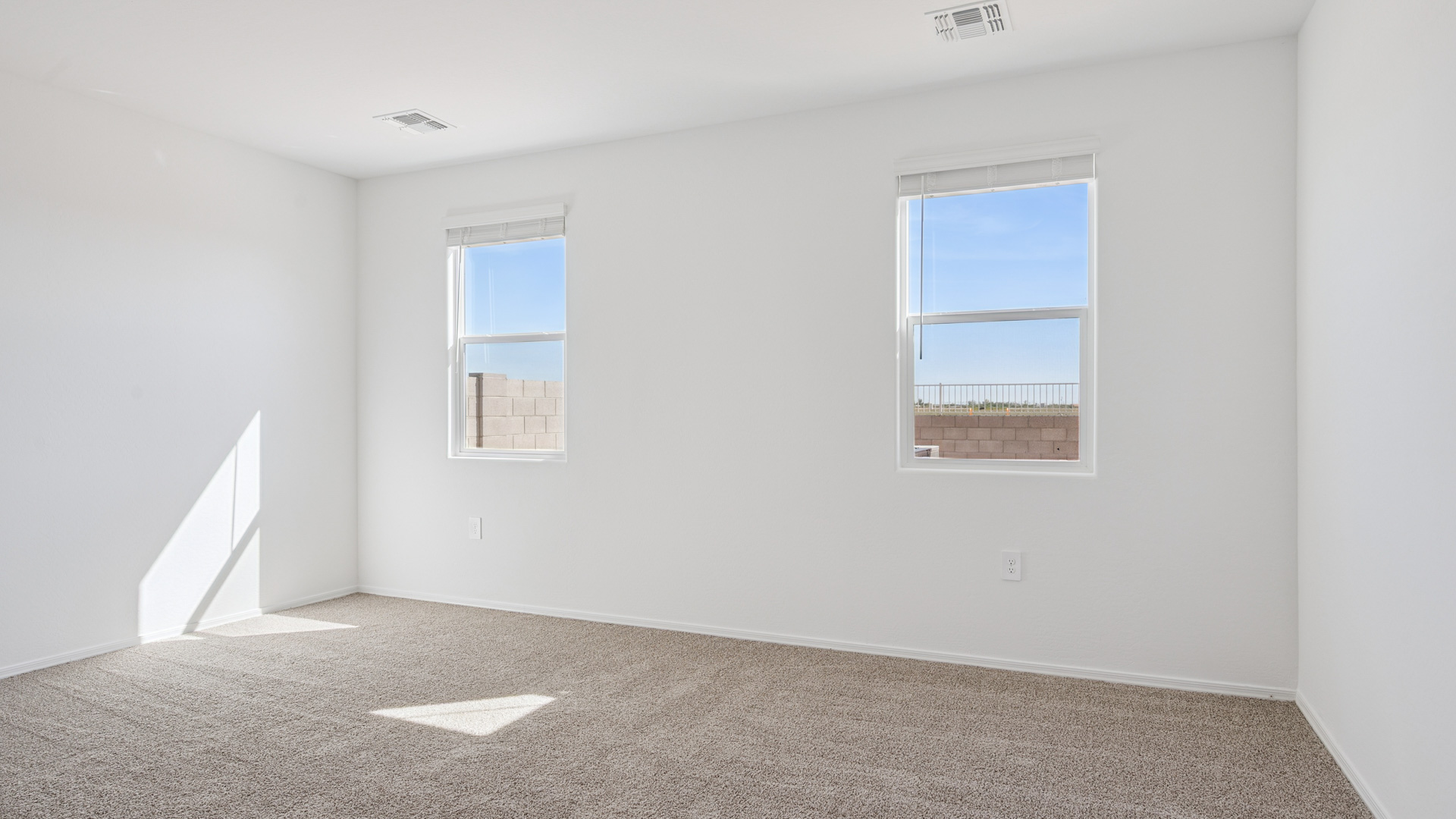 A spacious primary bedroom emphasizing open space and natural lighting.