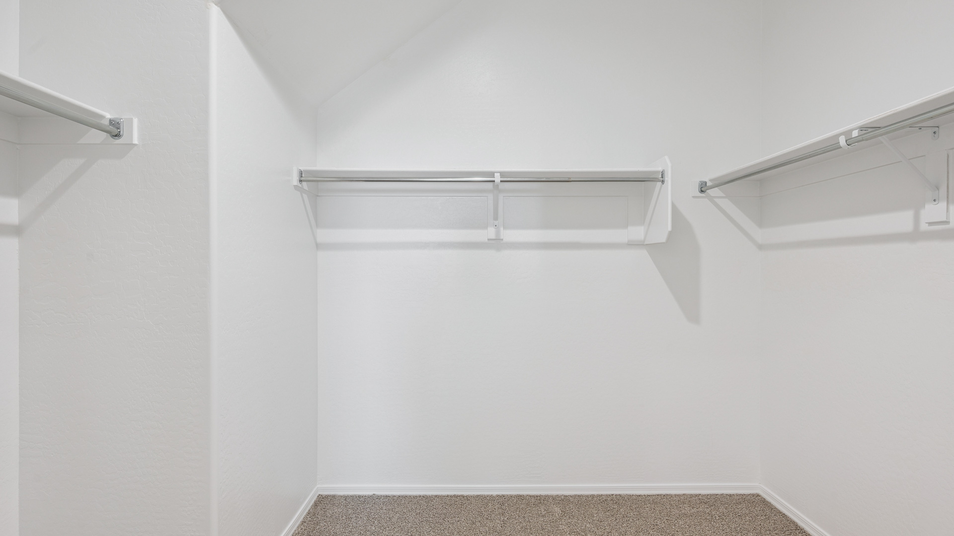 Modern primary bathroom with double vanity, granite countertops with a walk-in shower and a walk-in closet.
