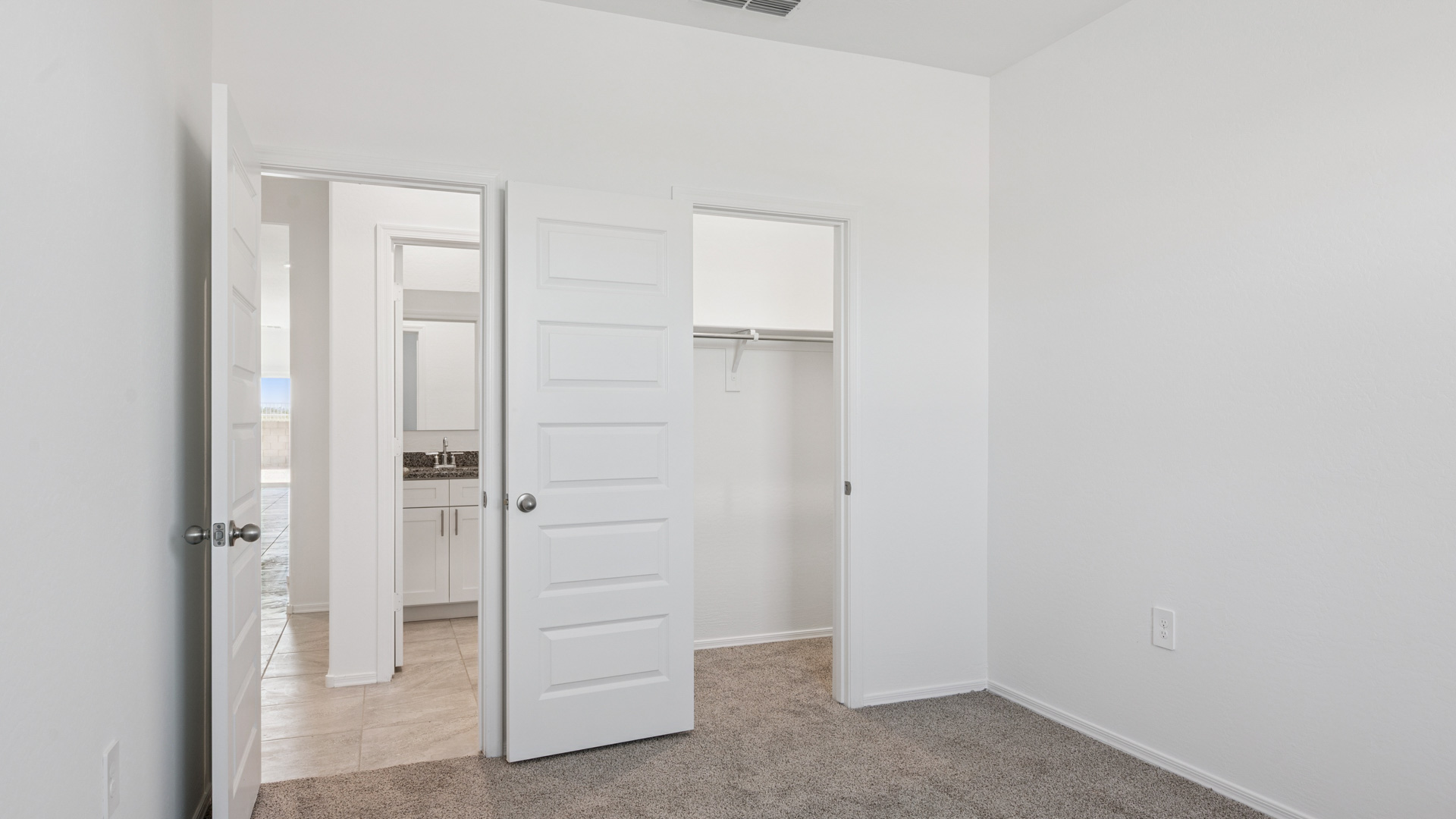 Comfortable guest bedroom featuring neutral-toned walls and a large closet.