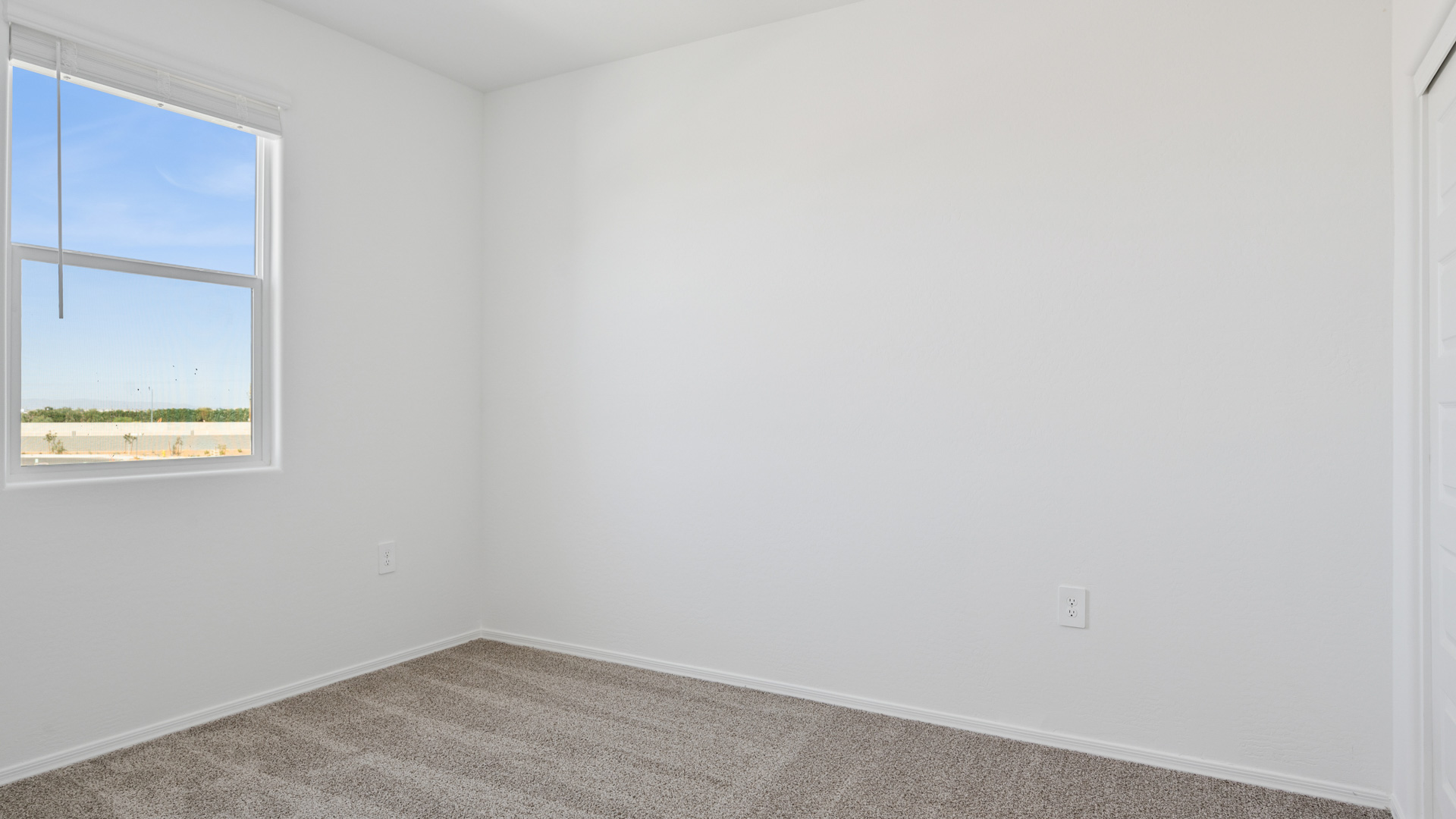 Comfortable guest bedroom featuring neutral-toned walls and a large closet.