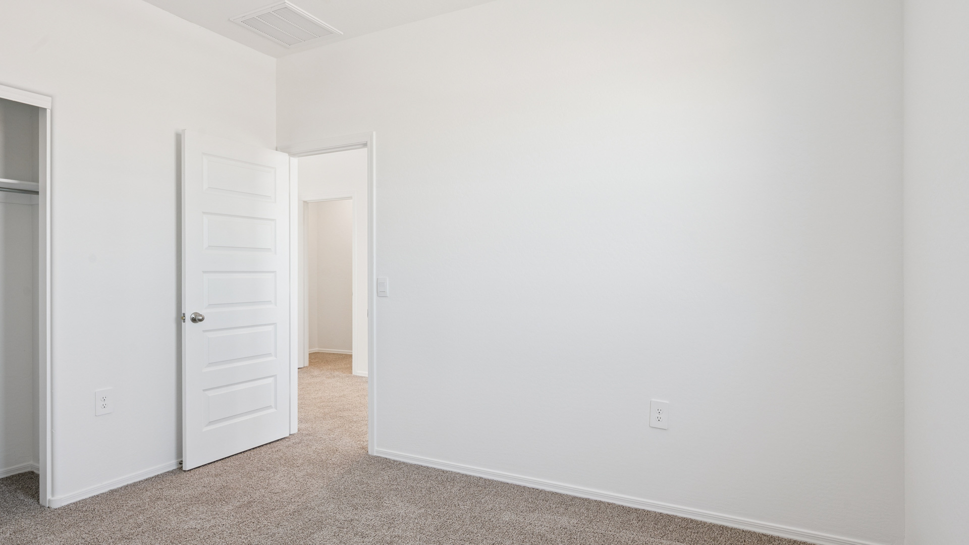 Comfortable guest bedroom featuring neutral-toned walls and a large closet.