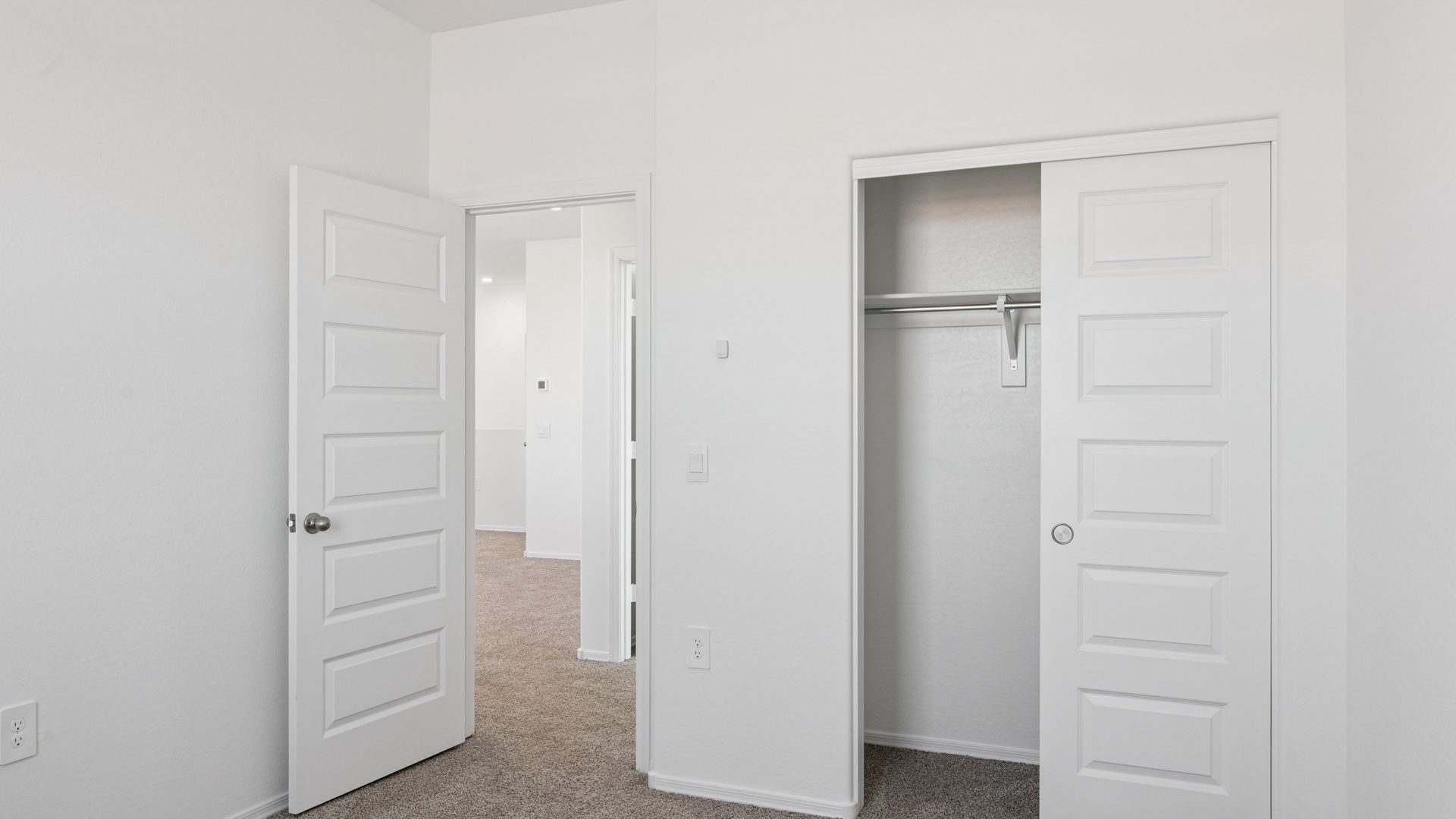 Comfortable guest bedroom featuring neutral-toned walls and a large closet.