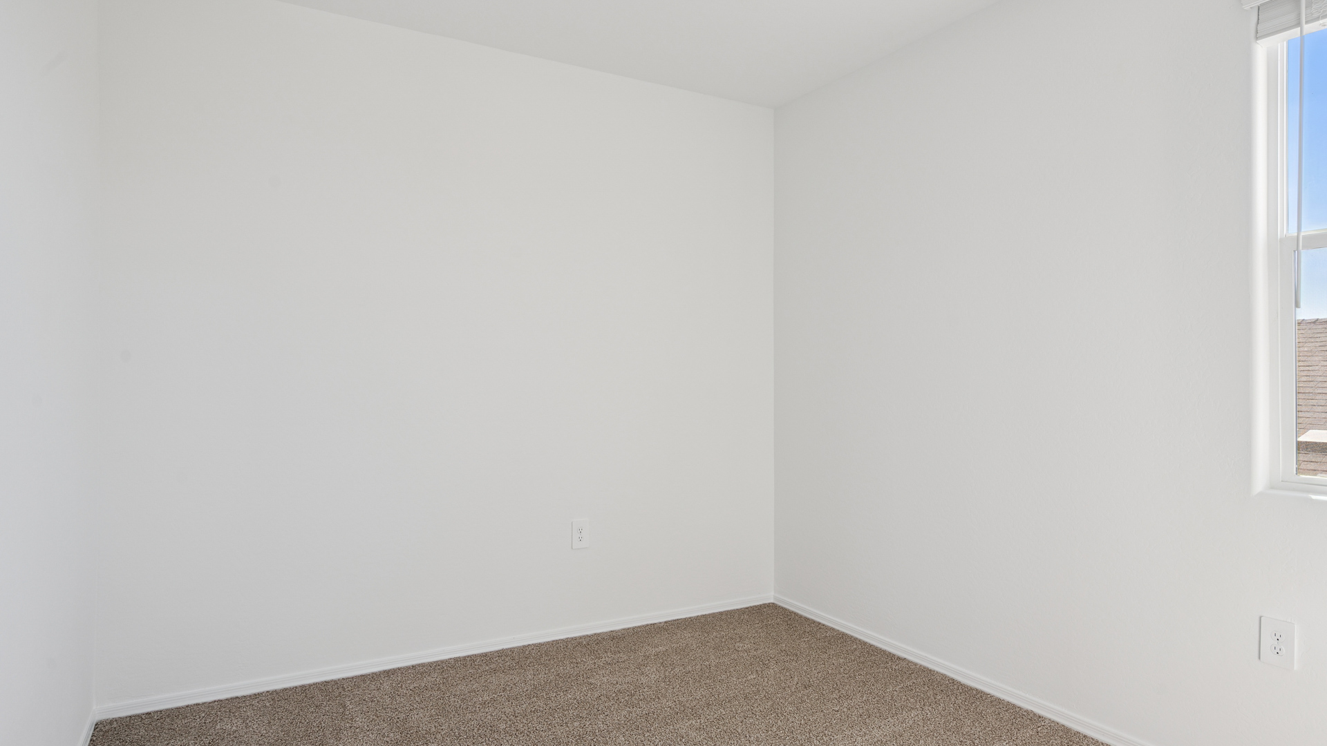 Comfortable guest bedroom featuring neutral-toned walls and a large closet.