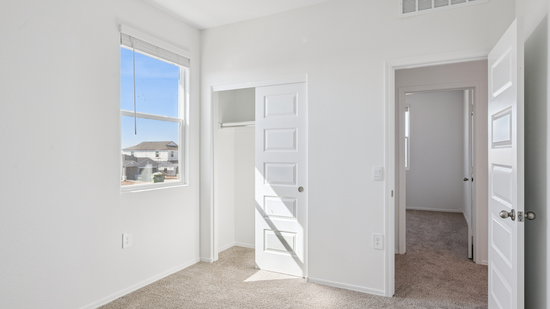 Comfortable guest bedroom featuring neutral-toned walls and a large closet.