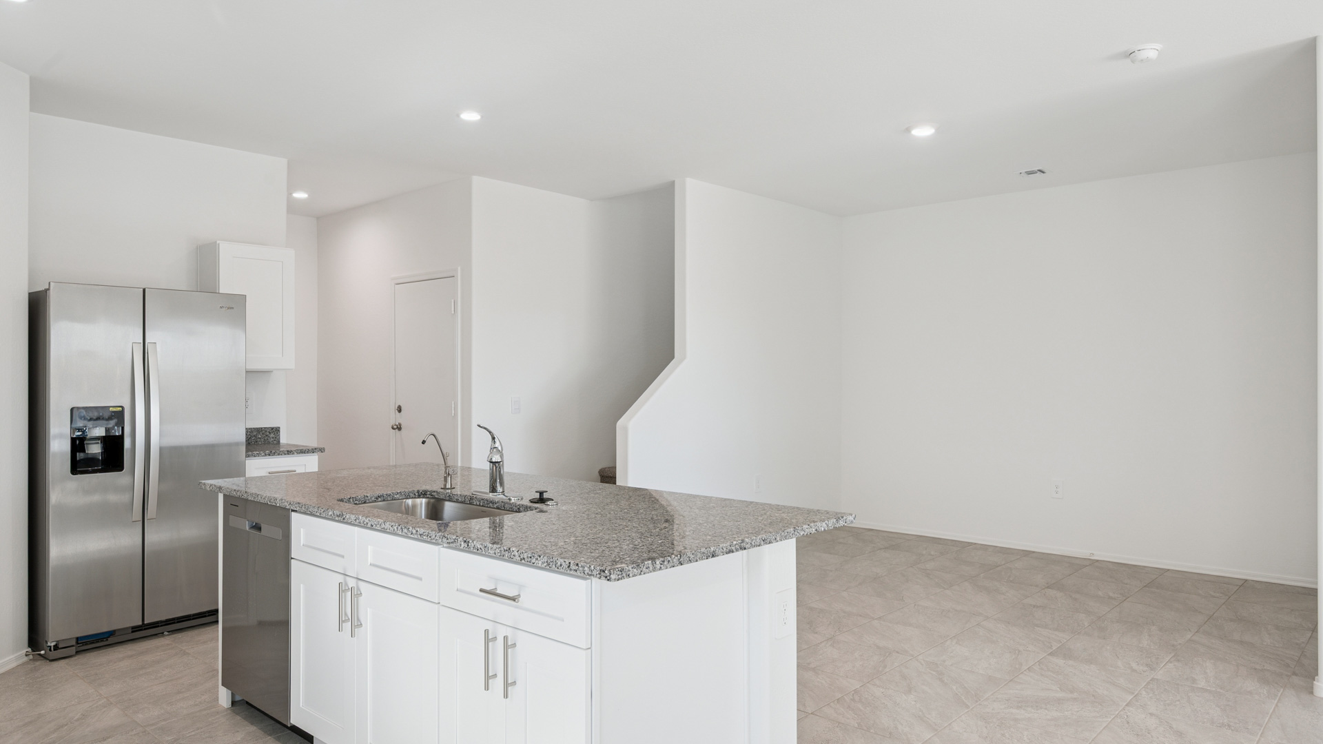Bright and spacious kitchen with granite countertops, stainless steel appliances, and an island with bar seating.