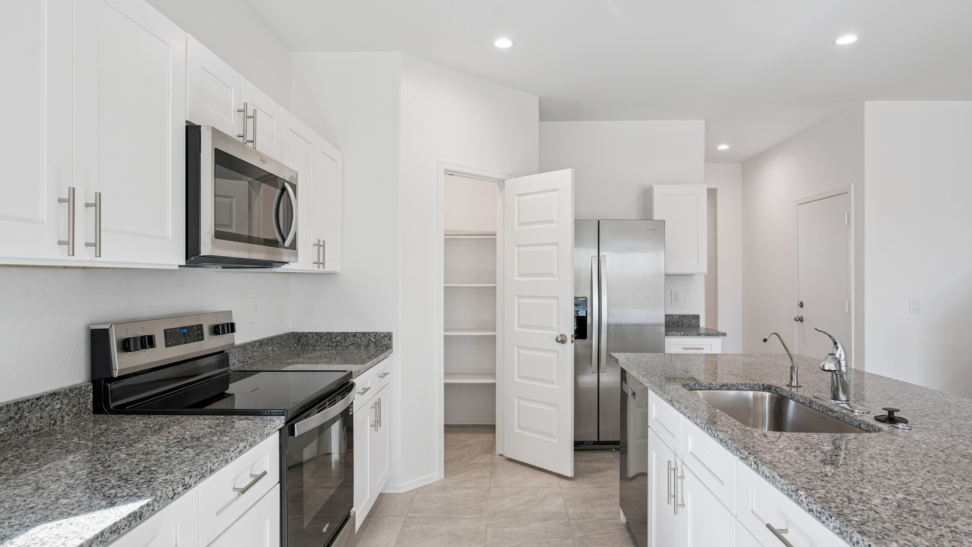 Bright and spacious kitchen with granite countertops, stainless steel appliances, and an island with bar seating.