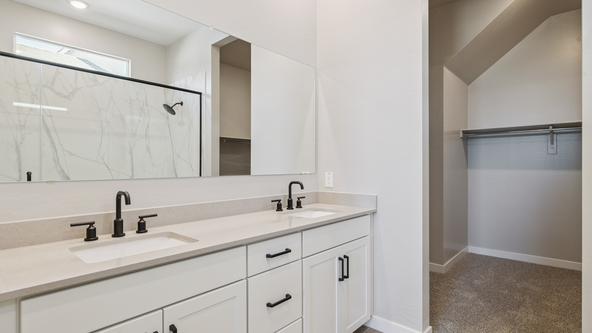 primary bathroom with dual vanities