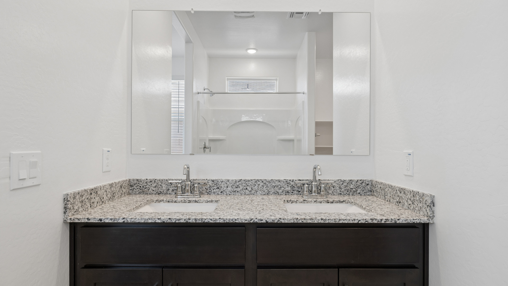 primary bathroom with dual vanities