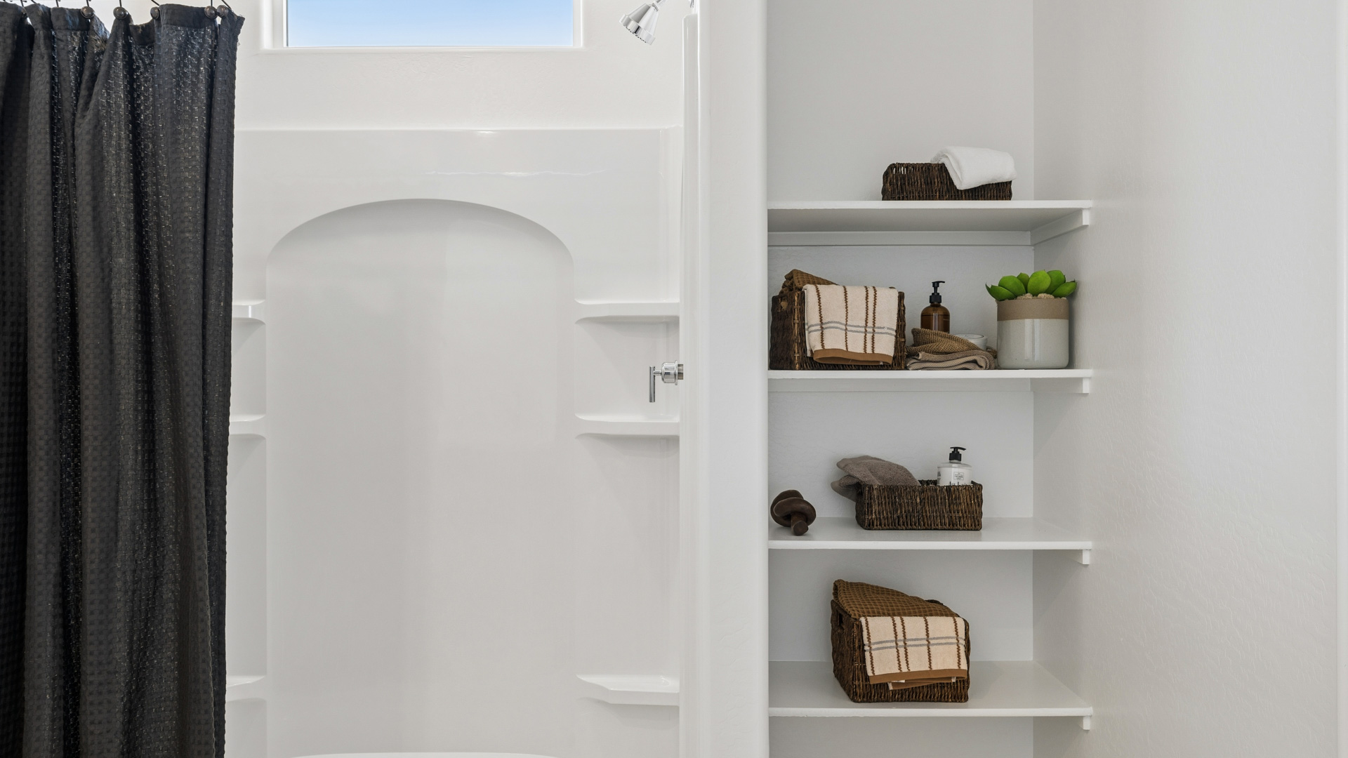 Modern primary bathroom with double vanities, porcelain countertops with a walk-in shower and a walk-in closet.