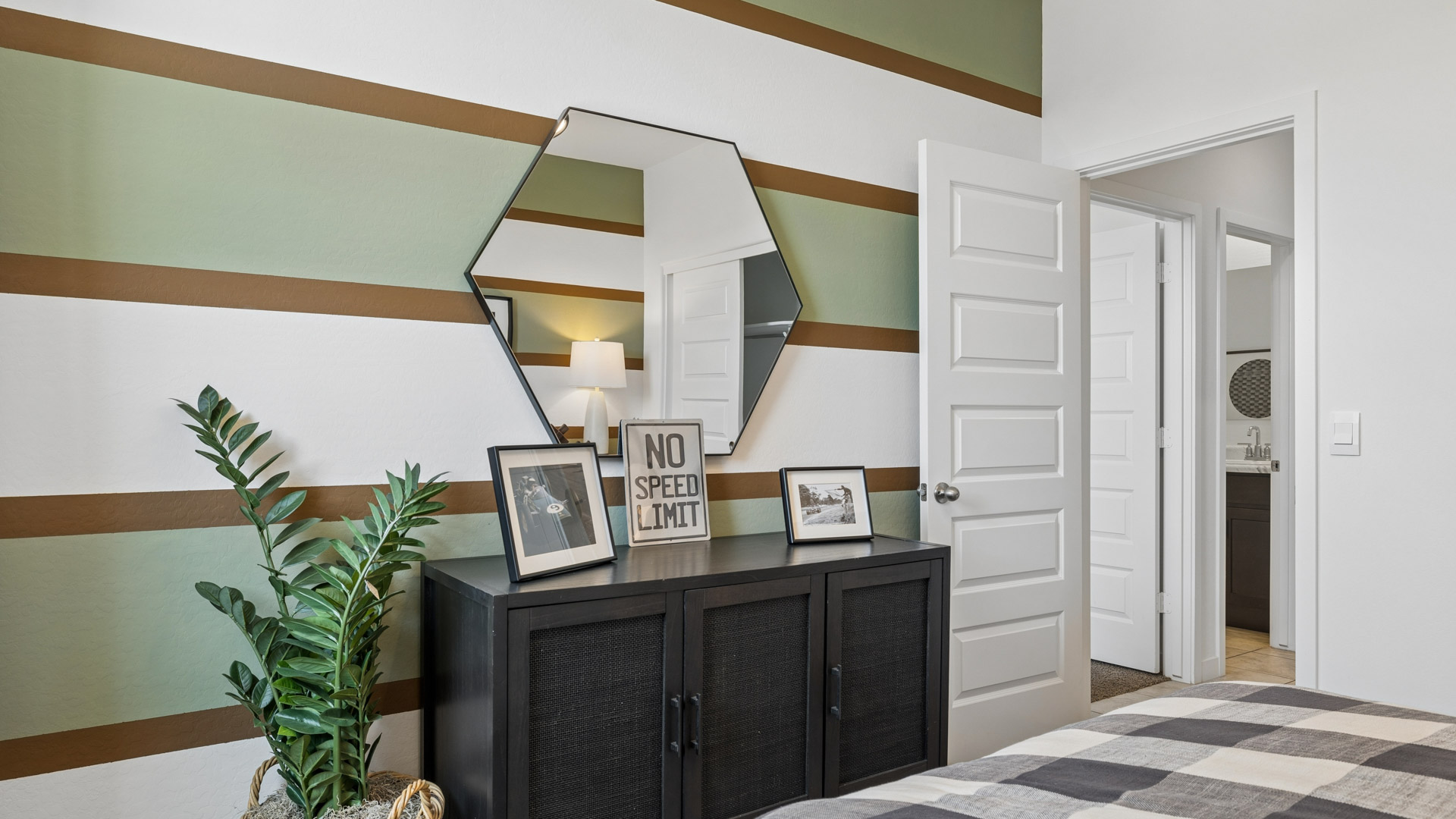 A vibrant kids' bedroom showcasing a neatly made bed, a stylish dresser, and a playful painting that adds charm.
